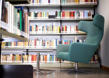 Die Bibliothek des BdV Hessen. Eine Ecke mit Regalen und einem Sessel.